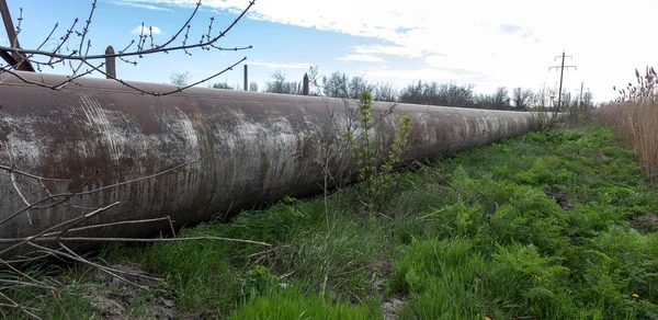 An old rusty large iron pipe of an outdated industrial waterpipe, Odessa, Ukraine, 2018. Large worn-out iron pipes for water supply of the city