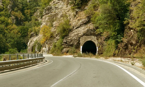 A winding mountain road. Two-way road in the mountains. Paved highway in a mountainous area near the rocky slopes of stone