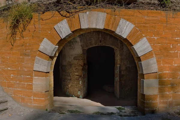 An old abandoned tunnel in an underground wine cellar. Entrance to catacombs. Dungeon Old stone fortress. As creative background for staging dark design. Mystical interior of ancient dungeon