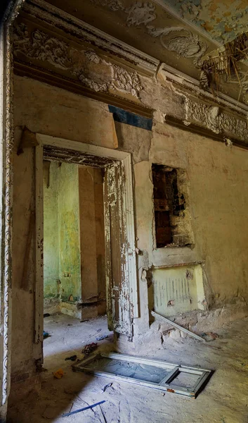 Mystical interior, ruins of an abandoned ruined building of an ancient 18th century building. Old ruined walls, corridor with garbage and mud. Destroyed molding, gypsum decorations, bas-relief