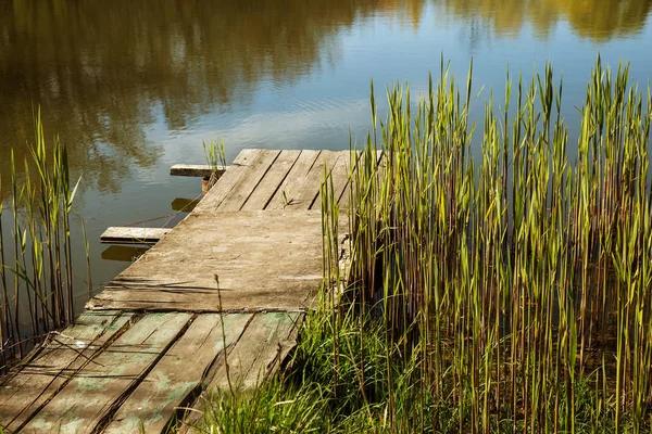 Rustik ahşap eski köprü. deforme olmuş ve harap ahşap köprüden kanal, imha ahşap köprü imha kavramı. Nehri üzerinde ahşap çıta ile kırsal yaya köprüsü
