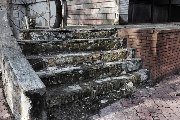 Eski, açık, taştan bir merdiven. Taş, eski merdivenlerin çimento basamaklarında yıpranma ve yıpranma izleri var. Eski taş bir merdiven, eski kırık basamaklar. Seçici odak