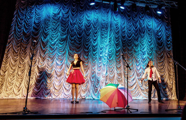 Odessa, Ukraine - December 24, 2015: Children's musical groups singing and dancing on stage in bright colorful clothes. Emotional, touching children's musical stage show.