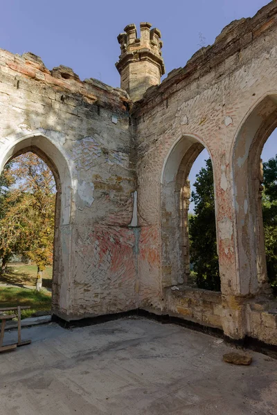 Mystical interior, ruins of facade of abandoned ruined building of ancient castle, mansion. Old ruined walls, corridor with garbage and mud. Ruins Ancient historical building, destroyed by vandals