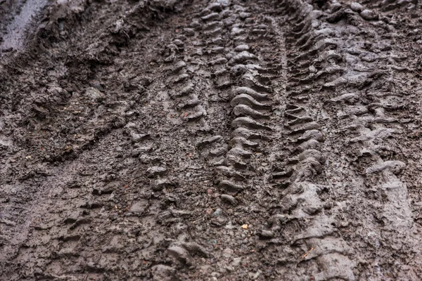 Dirt slippery imprint of auto tires on the clay. Wheel road on dirt off-road. A dirty clay road, wet in spring. Traces extreme driving off-road. Track from the car. Background with soft short focus