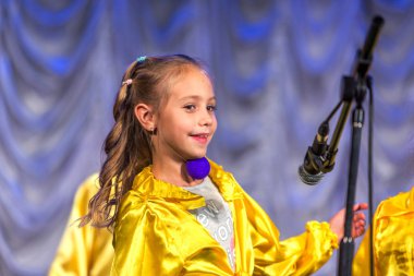 Odessa, Ukrayna - 24 Aralık 2015: şarkı ve parlak renkli kıyafetler içinde sahnede dans çocuk müzik grupları. Duygusal, çocukların müzik sahne gösterisi dokunmadan.