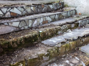 Eski, açık, taştan bir merdiven. Taş, eski merdivenlerin çimento basamaklarında yıpranma ve yıpranma izleri var. Eski taş bir merdiven, eski kırık basamaklar. Seçici odak