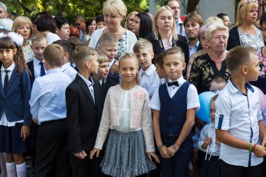 Odessa, Ukrayna 1 Eylül 2017: Okul bahçesinde öğrenciler ve öğretmenler ile okul çizgi var. Çocuklar okula geri dön. Bilgi gün, okulun ilk günü. Birinci sınıf öğrencileri sınıfta oturmak