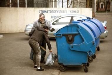 Odessa, Ukrayna -1 Nisan 2017: evsiz serseriler kim are seyir için çöp tenekeleri yakınındaki boş şişeleri ve gıda artıkları. Evsizler sorunu. Dilenciler - işsiz, mülteciler, göçmenler