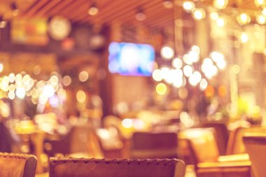 Küçük bir restoranın içi bulanık bir arka plan. Bokeh Kafe 'nin içini sıcak koyu renklerle bulanıklaştırmış. Yaratıcı moda tasarımı için arka plan olarak.