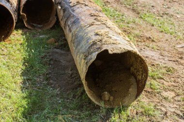 Eski büyük su boruları parçaları. Sonra uzun yıllar çalışma aşınmış metal boru yok. Paslı çelik boru delik metal korozyon ile. Seçici odak.