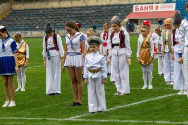 Odessa, Ukrayna - 21 Ekim 2017: Sahne alanı'nda çocuk. Genç çocuk topluluğu Stadyumu yeşil çimenlerin üzerinde Ulusal kostüm dans dans. Stadyumda dans çocuk