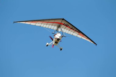 Odessa, Ukrayna - 27 Temmuz 2011: Küçük Moto hang glider soars seyirciler performansları sırasında yukarıdaki mavi gökyüzünde yüksek irtifada Odessa geleneksel hava gösterisinde üzerinde