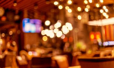 Küçük bir restoranın içi bulanık bir arka plan. Bokeh Kafe 'nin içini sıcak koyu renklerle bulanıklaştırmış. Yaratıcı moda tasarımı için arka plan olarak.