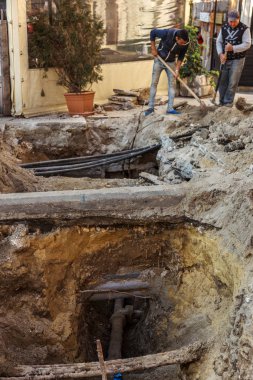 Varna, Bulgaristan - 16 Kasım 2015: İnşaat işçileri olun kentsel Karayolları mühendislik onarır. Onarım ve yedek su, kanalizasyon, elektrik ve kablo döşeme modern optik iletişim