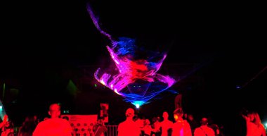 Odessa, Ukrayna - 5 Ağustos 2017: Lazer gösterisi. Gece kulübünde parti parlak performansı. Yaratıcı ışık gösterisi, siluetleri kalabalık dans pistinde. duman duman makinenin ışık resimde. Stilize film, tahıl, bozulma, hareket bulanıklığı