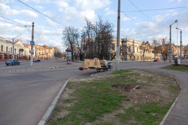 Odessa, Ukrayna - 29 Şubat 2017: Bir bisiklet üzerinde oturan evsiz biri Bagaj ile uyuyor. Evsiz bir bisiklet üzerinde yaşıyor ve yolun tam evinin karton kutu uyur