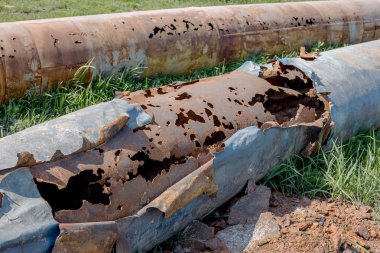 Eski büyük su boruları parçaları. Sonra uzun yıllar çalışma aşınmış metal boru yok. Paslı çelik boru delik metal korozyon ile. Seçici odak.