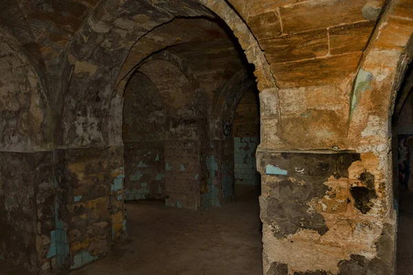 An old abandoned tunnel in an underground wine cellar. Entrance to catacombs. Dungeon Old stone fortress. As creative background for staging dark design. Mystical interior of ancient dungeon