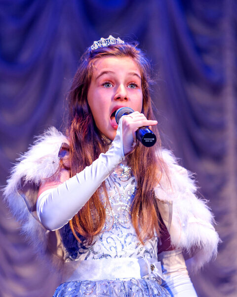 Odessa, Ukraine - December 24, 2015: Children's musical groups singing and dancing on stage in bright colorful clothes. Emotional, touching children's musical stage show.