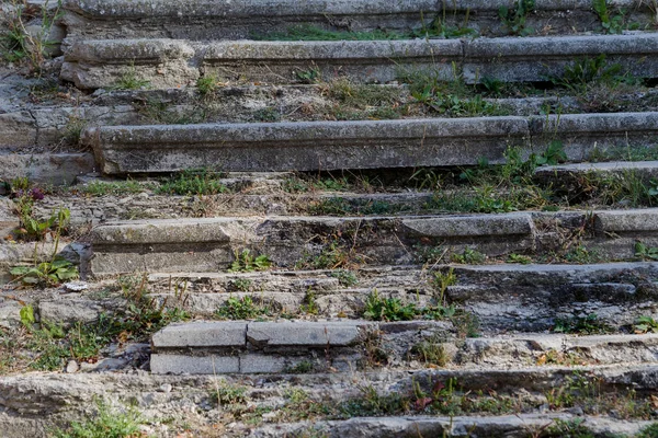 An old outdoor outdoor stone staircase. Stone, cement steps of old staircase with traces of weathering and destruction. Vintage stone staircase, ancient broken steps. Selective focu