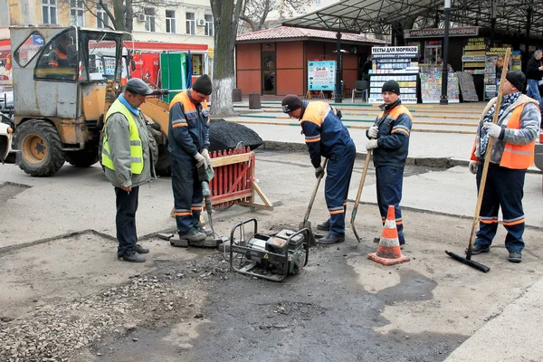 Odessa - April 3: a team of workers repairs road under the program of urban planning repairs after winter frosts that destroyed an asphalt road . April 3, 2014 in Odessa, Ukraine