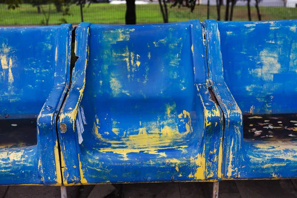 Empty old plastic chairs for spectators. Number of empty seats in old small place. Scratched worn blue plastic seats for important fan visitors. Rows of plastic fiberglass chairs on platform ferry bus