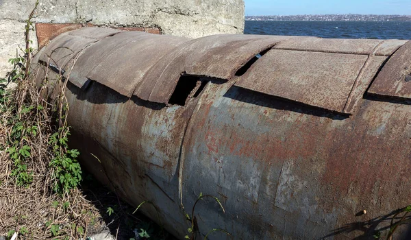 An old rusty large iron pipe of an outdated industrial waterpipe, Odessa, Ukraine, 2018. Large worn-out iron pipes for water supply of the city