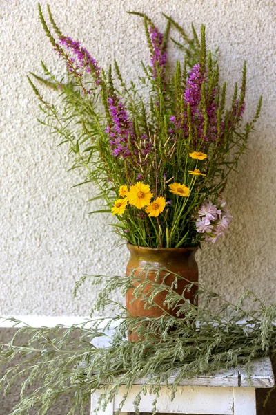 Bouquet of freshly beautiful wildflowers in vasel. Field medicinal flowers of blooming Sally in bouquet. Field bitter wormwood. beautiful bouquet of bright wildflowers in an antique vintage vase