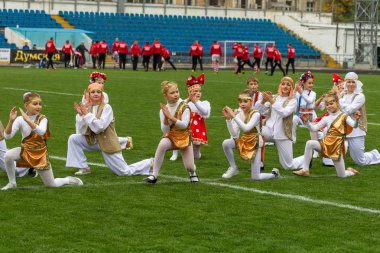 Odessa, Ukrayna - 21 Ekim 2017: Sahne alanı'nda çocuk. Genç çocuk topluluğu Stadyumu yeşil çimenlerin üzerinde Ulusal kostüm dans dans. Stadyumda dans çocuk