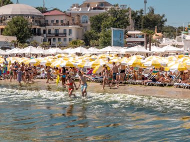 Odessa, Ukrayna - 10 Ağustos 2013: Turist güneşlenmek, yüzmek ve eğleniyor plajda dinlenebilir. Turizm Avrupa'nın en önemli yerlerinden biridir. Sıcak yaz. İyi tatil sezonu. Birçok turist