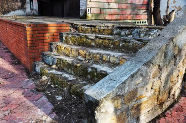 Eski, açık, taştan bir merdiven. Taş, eski merdivenlerin çimento basamaklarında yıpranma ve yıpranma izleri var. Eski taş bir merdiven, eski kırık basamaklar. Seçici odak