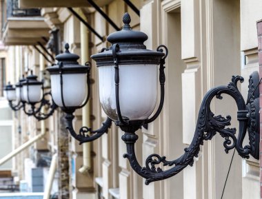 Vintage bronz beyaz sokak ışıkları öğleden sonra evin duvarında bir satırda