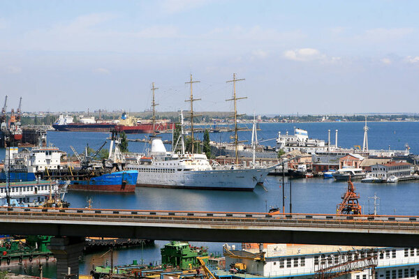 ODESSA, UKRAINE - APRIL 15: maritime cargo ships and sailboat moored in the harbor of Odessa sea port . Landscape view of the Bread harbor port , April 15, 2014 Odessa, Ukraine