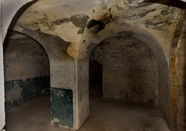 An old abandoned tunnel in an underground wine cellar. Entrance to catacombs. Dungeon Old stone fortress. As creative background for staging dark design. Mystical interior of ancient dungeon