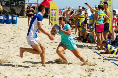 Odessa, Ukrayna - 27 Ağustos 2017: Uluslararası Rugby Festivali kum deniz Beach Zatoka Z-Oyunlar Spor ve müzik festivali sırasında üzerinde. Rugby oyuncuları erkekler ve kadınlar sahil kumu eylem içinde