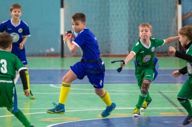 Odessa, Ukrayna - Hazi 24,2018: Küçük çocuklar kapalı salonunda şehir okulun derby Oyunlar sırasında rugby oynamak. Çocuk spor. Çocuk rugby 5 oyun. Çocuk zafer için mücadele. Sağlıklı yaşam tarzı