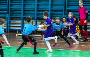 Odessa, Ukrayna - Hazi 24,2018: Küçük çocuklar kapalı salonunda şehir okulun derby Oyunlar sırasında rugby oynamak. Çocuk spor. Çocuk rugby 5 oyun. Çocuk zafer için mücadele. Sağlıklı yaşam tarzı