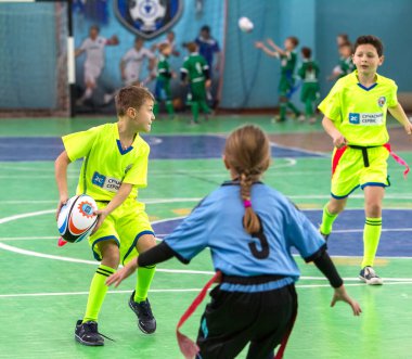 Odessa, Ukrayna - Hazi 24,2018: Küçük çocuklar kapalı salonunda şehir okulun derby Oyunlar sırasında rugby oynamak. Çocuk spor. Çocuk rugby 5 oyun. Çocuk zafer için mücadele. Sağlıklı yaşam tarzı