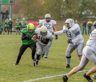 Odessa, Ukrayna - 7 Kasım 2015: Ukrayna Kupası Amerikan futbolu korsanlar - Odessa ve aslanlar - aslanlar. Erkekler maç sırasında gergin anı scrum. Spor zorlu mücadele.