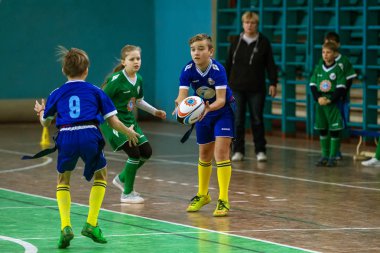 Odessa, Ukrayna - Hazi 24,2018: Küçük çocuklar kapalı salonunda şehir okulun derby Oyunlar sırasında rugby oynamak. Çocuk spor. Çocuk rugby 5 oyun. Çocuk zafer için mücadele. Sağlıklı yaşam tarzı