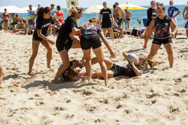 Odessa, Ukrayna - 27 Ağustos 2017: Uluslararası Rugby Festivali kum deniz Beach Zatoka Z-Oyunlar Spor ve müzik festivali sırasında üzerinde. Rugby oyuncuları erkekler ve kadınlar sahil kumu eylem içinde