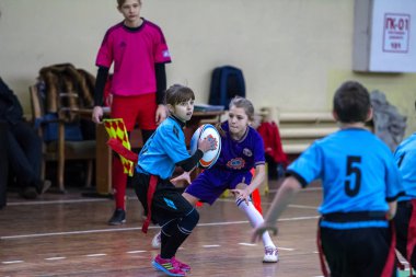 Odessa, Ukrayna - Hazi 24,2018: Küçük çocuklar kapalı salonunda şehir okulun derby Oyunlar sırasında rugby oynamak. Çocuk spor. Çocuk rugby 5 oyun. Çocuk zafer için mücadele. Sağlıklı yaşam tarzı