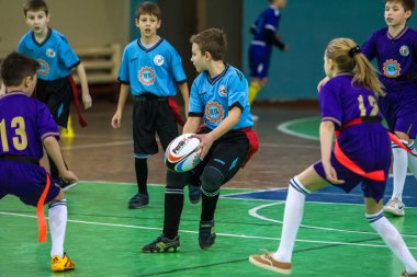 Odessa, Ukrayna - Hazi 24,2018: Küçük çocuklar kapalı salonunda şehir okulun derby Oyunlar sırasında rugby oynamak. Çocuk spor. Çocuk rugby 5 oyun. Çocuk zafer için mücadele. Sağlıklı yaşam tarzı