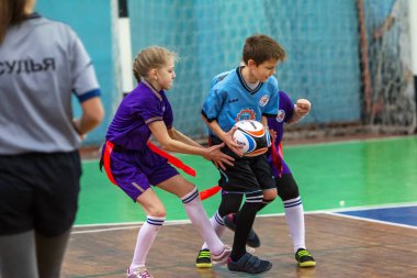 Odessa, Ukrayna - Hazi 24,2018: Küçük çocuklar kapalı salonunda şehir okulun derby Oyunlar sırasında rugby oynamak. Çocuk spor. Çocuk rugby 5 oyun. Çocuk zafer için mücadele. Sağlıklı yaşam tarzı