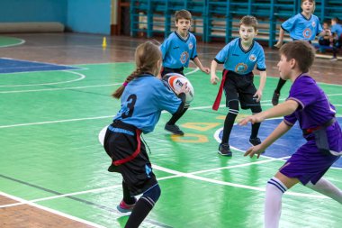 Odessa, Ukrayna - Hazi 24,2018: Küçük çocuklar kapalı salonunda şehir okulun derby Oyunlar sırasında rugby oynamak. Çocuk spor. Çocuk rugby 5 oyun. Çocuk zafer için mücadele. Sağlıklı yaşam tarzı