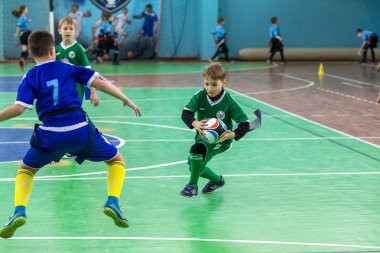 Odessa, Ukrayna - Hazi 24,2018: Küçük çocuklar kapalı salonunda şehir okulun derby Oyunlar sırasında rugby oynamak. Çocuk spor. Çocuk rugby 5 oyun. Çocuk zafer için mücadele. Sağlıklı yaşam tarzı
