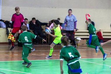 Odessa, Ukrayna - Hazi 24,2018: Küçük çocuklar kapalı salonunda şehir okulun derby Oyunlar sırasında rugby oynamak. Çocuk spor. Çocuk rugby 5 oyun. Çocuk zafer için mücadele. Sağlıklı yaşam tarzı