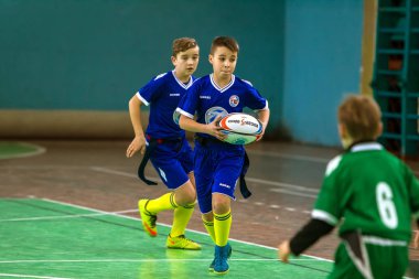 Odessa, Ukrayna - Hazi 24,2018: Küçük çocuklar kapalı salonunda şehir okulun derby Oyunlar sırasında rugby oynamak. Çocuk spor. Çocuk rugby 5 oyun. Çocuk zafer için mücadele. Sağlıklı yaşam tarzı