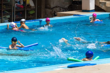 Varna, Bulgaristan - 31 Mayıs 2017: Büyüleyici mutlu çocuk çocuk yüzme havuzu ile banyo keyfini çıkarın. Koç yüzme havuzu çocuklarda öğretir. Spor çocuklar. Çocuk spor